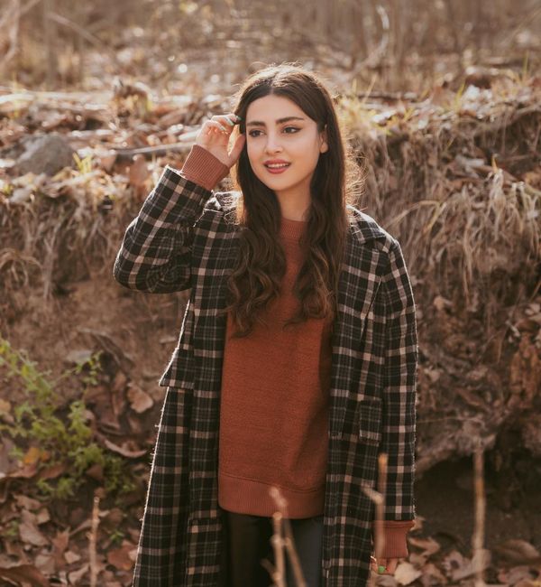 Person stretching gently outdoors with a serene natural background.